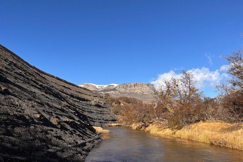 A river flowing through a rocky canyon with a clear blue sky and distant mountains. 3