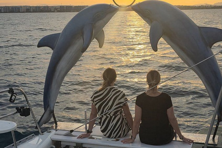 Two people on a boat with a dolphin sculpture. 2