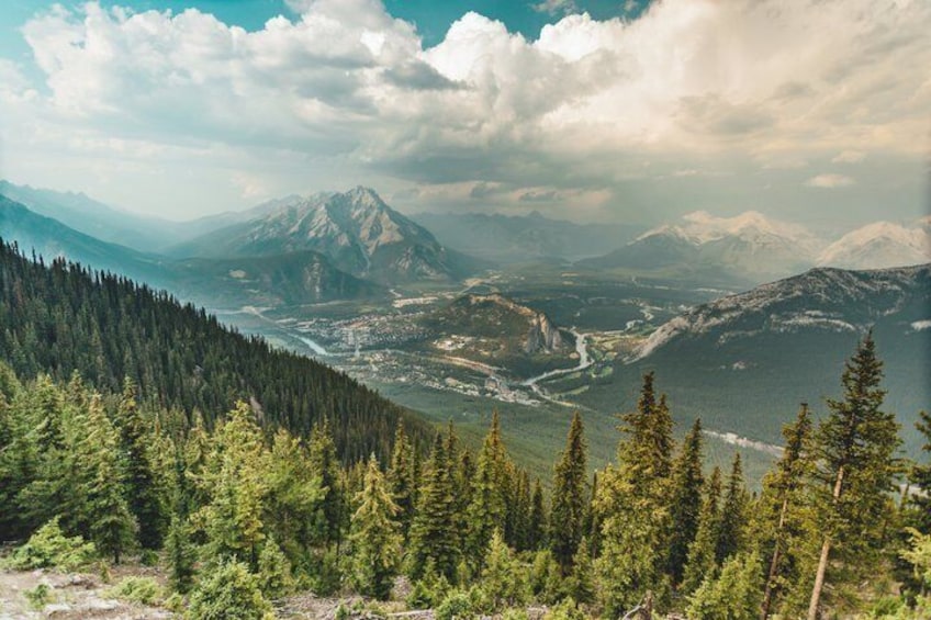 A mountainous landscape with dense forests, a river, and a prominent mountain peak. 2