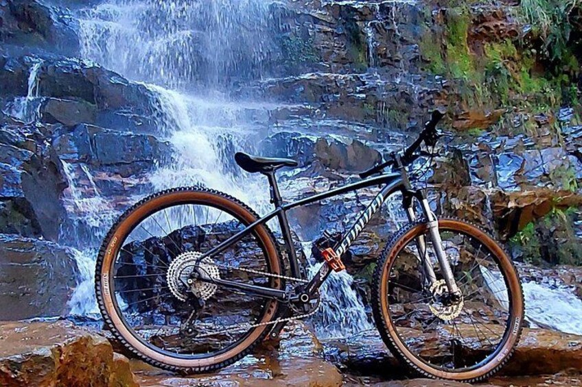 Un vélo tout-terrain garé près d’une cascade. 2