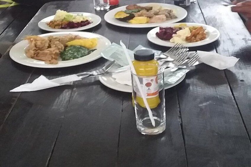 A table with plates of food, a glass bottle with a straw, and cutlery. 4