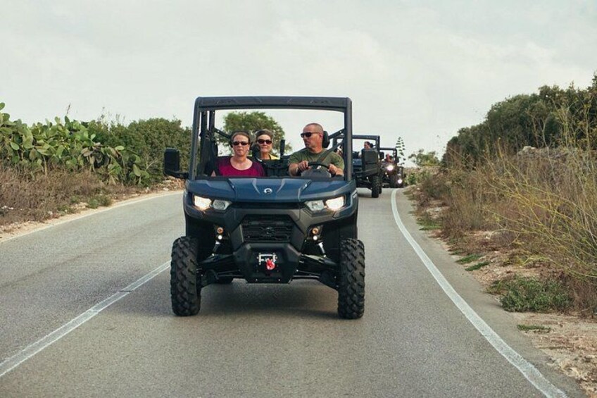 A vehicle on a paved road with vegetation on both sides. 2