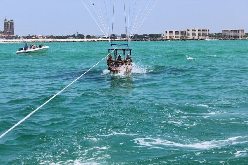 A parasailing boat with multiple people and a smaller boat in the background. 5