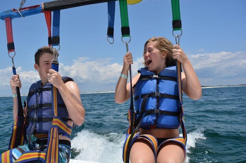 Two people on a swing ride over water. 3