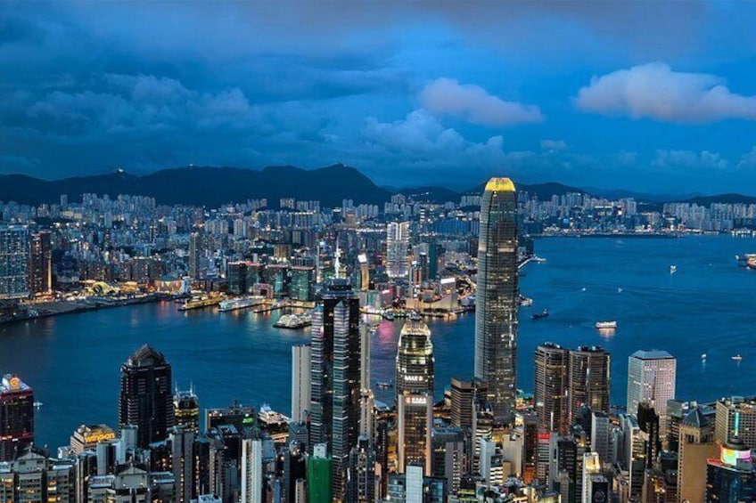 A cityscape with a prominent skyscraper, dense urban buildings, and a body of water. 3
