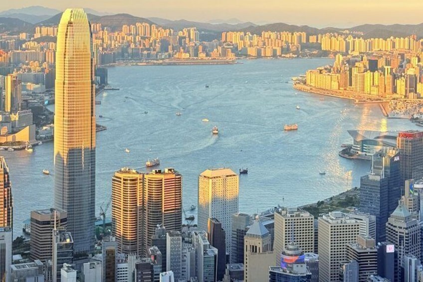 A cityscape with a prominent skyscraper, a body of water with boats, and surrounding high-rise buildings. 1