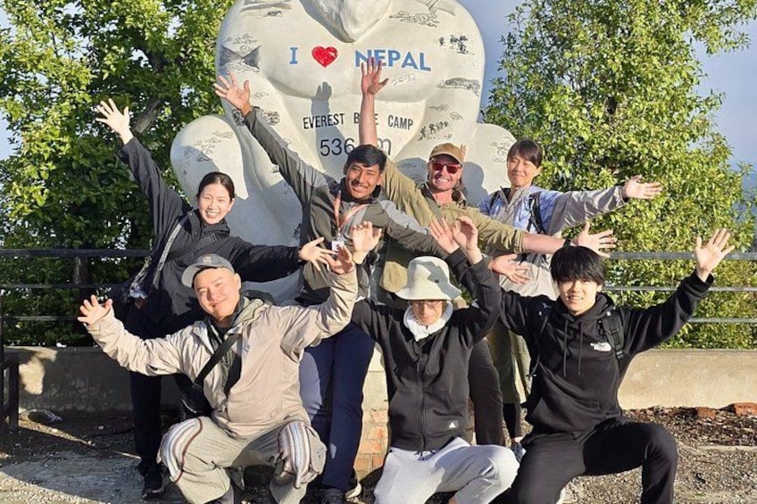 A group of people posing in front of a large sign with 'I ♥ NEPAL' and 'Everest Base Camp 5360' written on it. 2