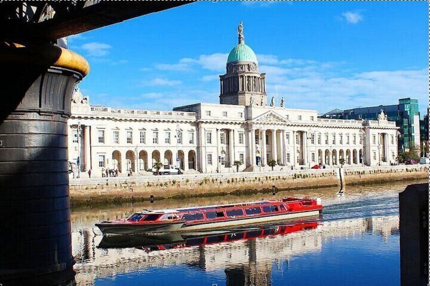 A riverboat on a river, a large white building with a green dome, and a bridge in the foreground. 1