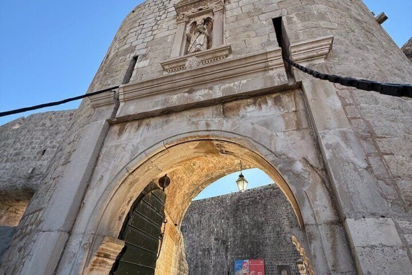 An old stone archway with a statue above it. 5