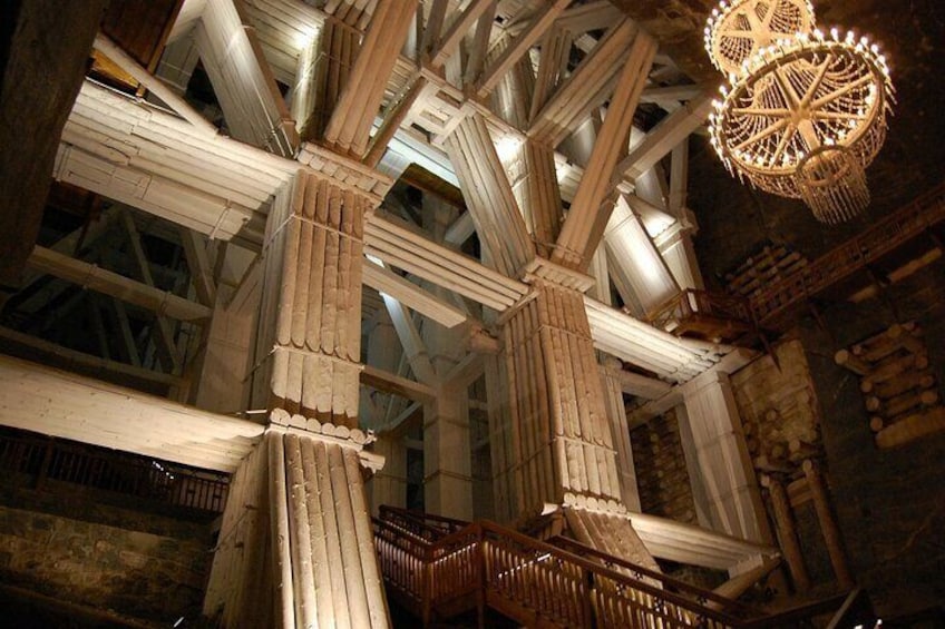 Une grande et somptueuse structure en bois, ornée de sculptures complexes et surmontée d’un lustre suspendu. 1