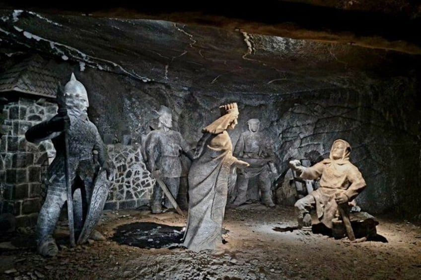 Une grotte ornée de statues en pierre et abritant une figure vêtue d’une robe. 3