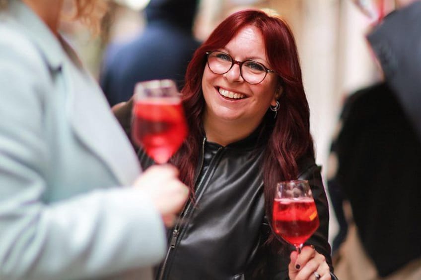 A person holding a red wine glass. 1
