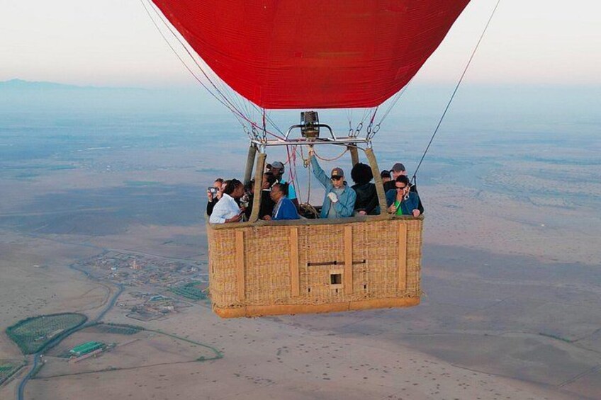 En luftballon med passagerer svæver over et stort landskab. 5