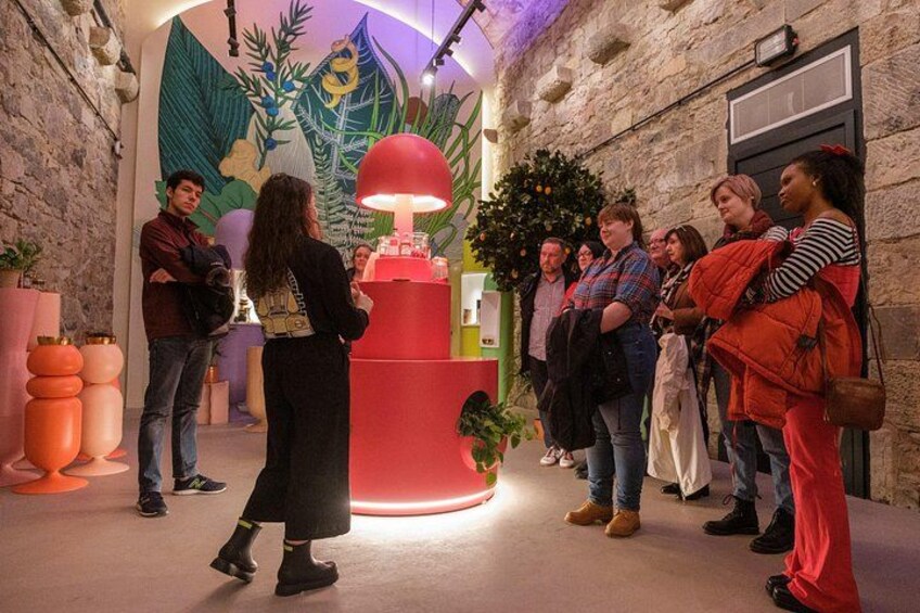 A group of people standing in a hallway with a red lamp and a Christmas tree. 3