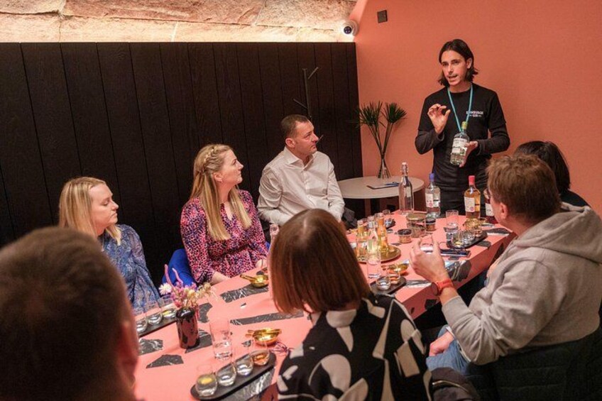 A group of people seated around a table with food and drinks, engaged in a discussion. 2