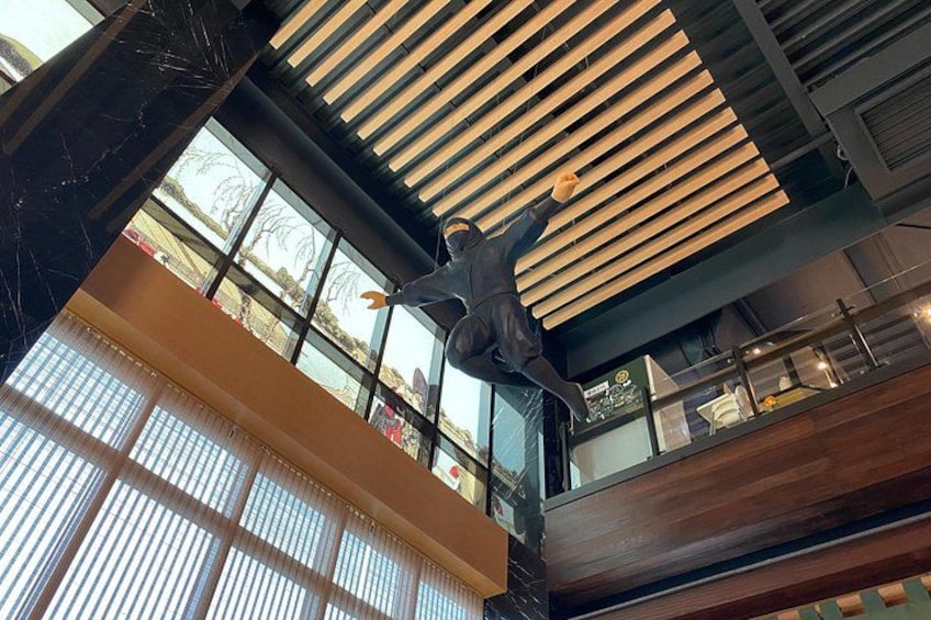 A modern interior with a large wooden slatted ceiling, large windows, and a statue. 2