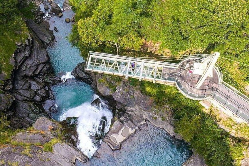 A suspension bridge over a river, surrounded by lush greenery. 4
