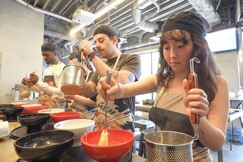Un cours de cuisine où les participants préparent des plats en utilisant différents ustensiles et ingrédients. 1