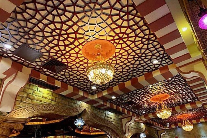 A ceiling with geometric patterns and hanging chandeliers. 2