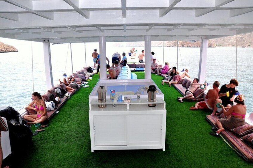 A boat with a green artificial turf area and a bar in the center. 2