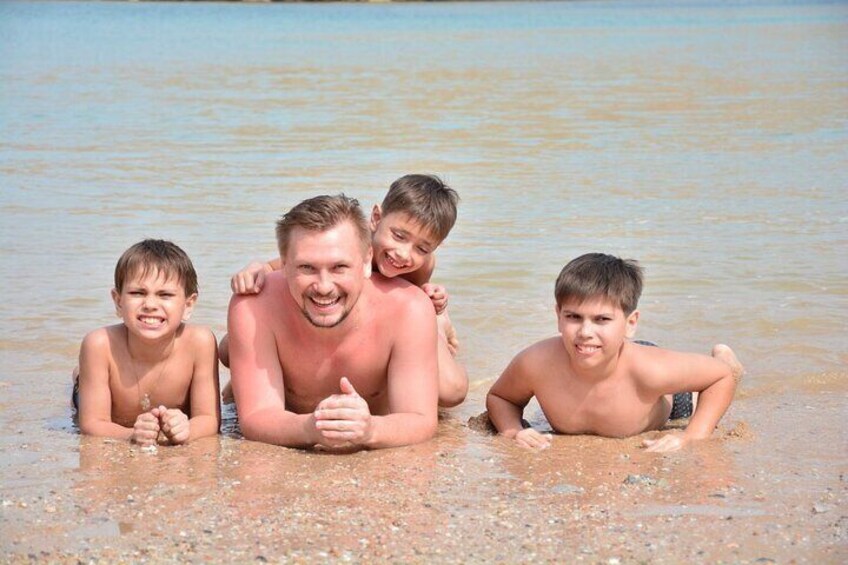 A family of four at a beach with clear water. 3
