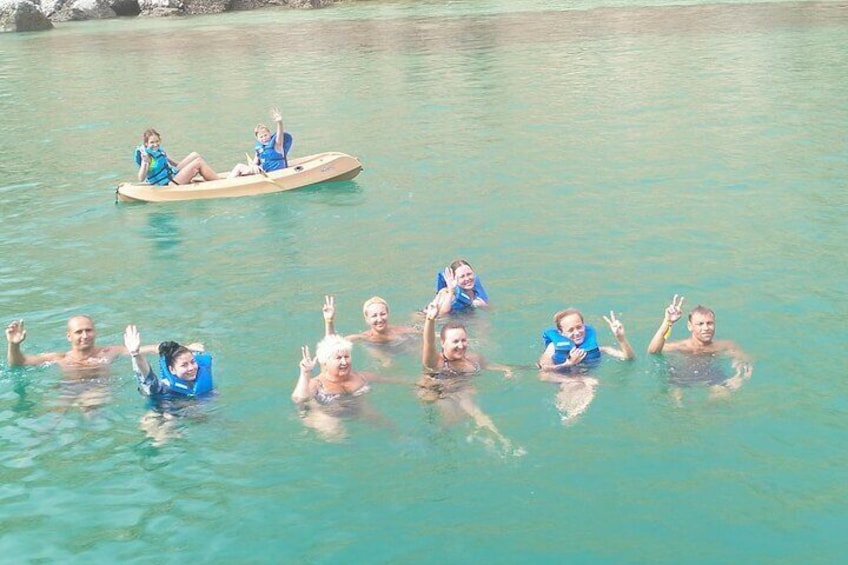 People swimming and floating in a turquoise body of water. 4