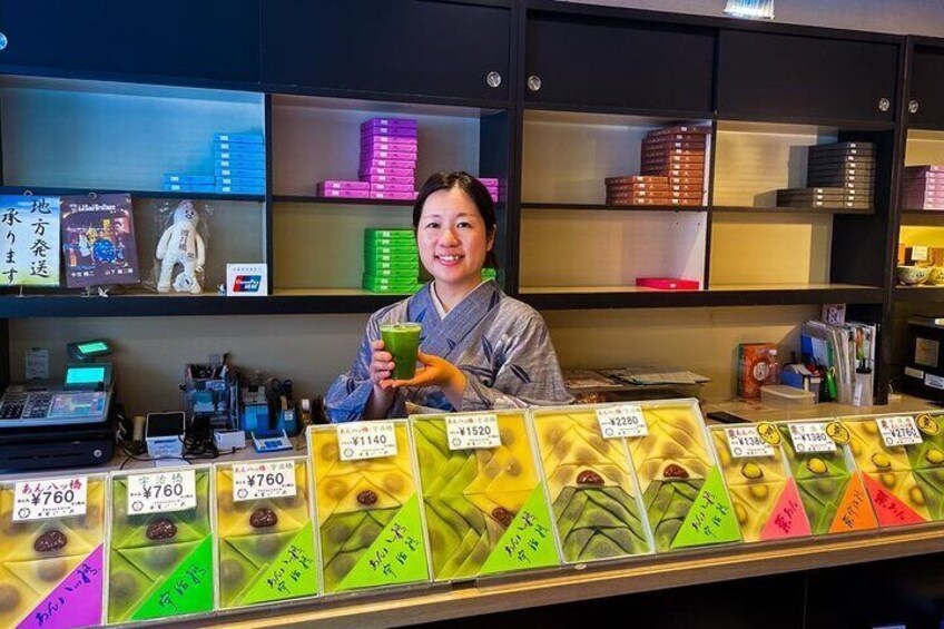 A person behind a counter with various items and price tags. 3