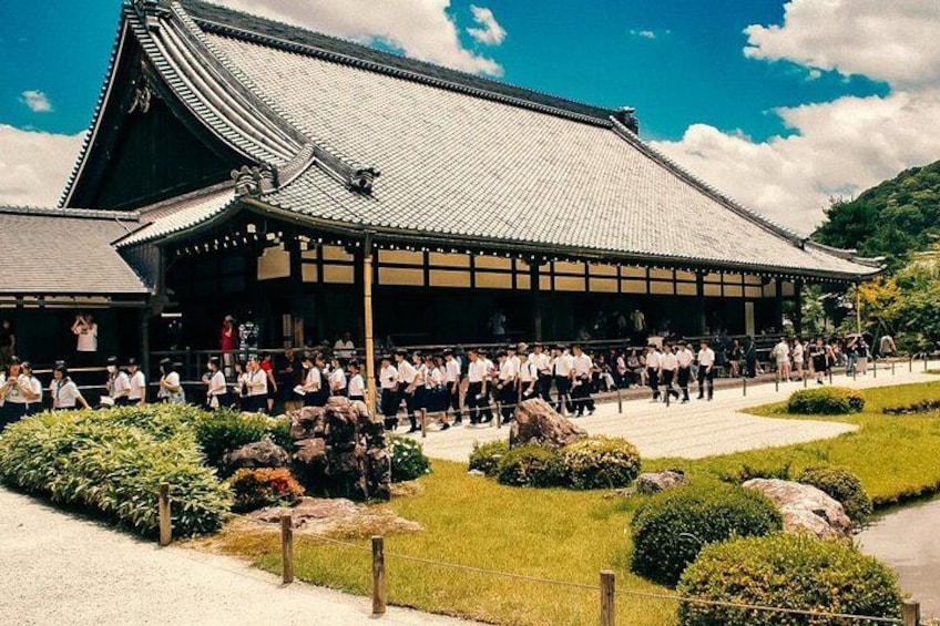 A traditional Japanese building with a tiled roof and a group of people in front. 4