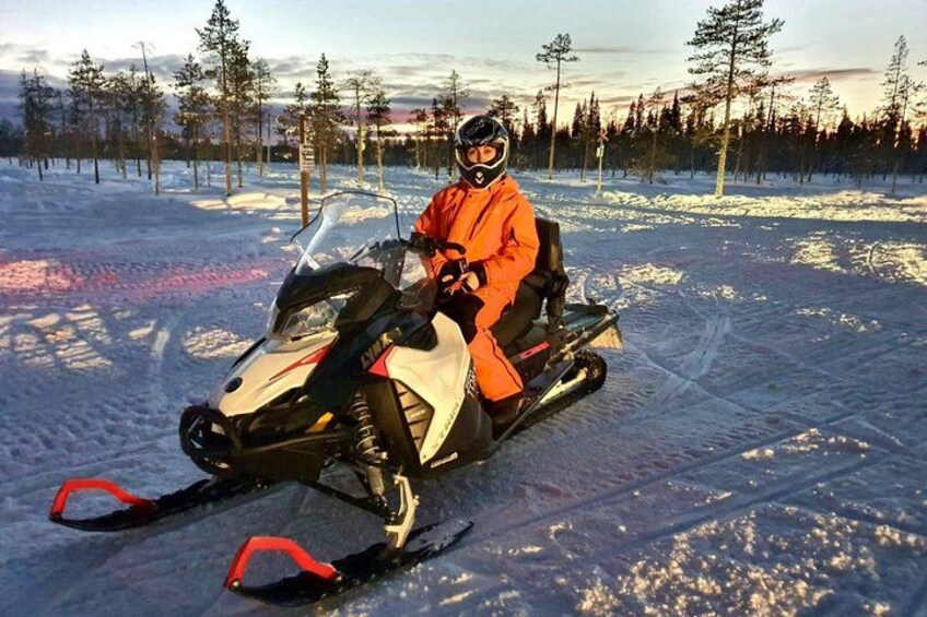 Una persona en un vehículo de nieve en un paisaje nevado con árboles. 5