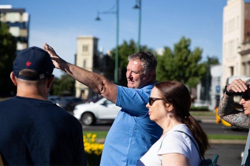 People outdoors, one person wearing a blue shirt, another in a white shirt, and a third in a dark shirt. 2
