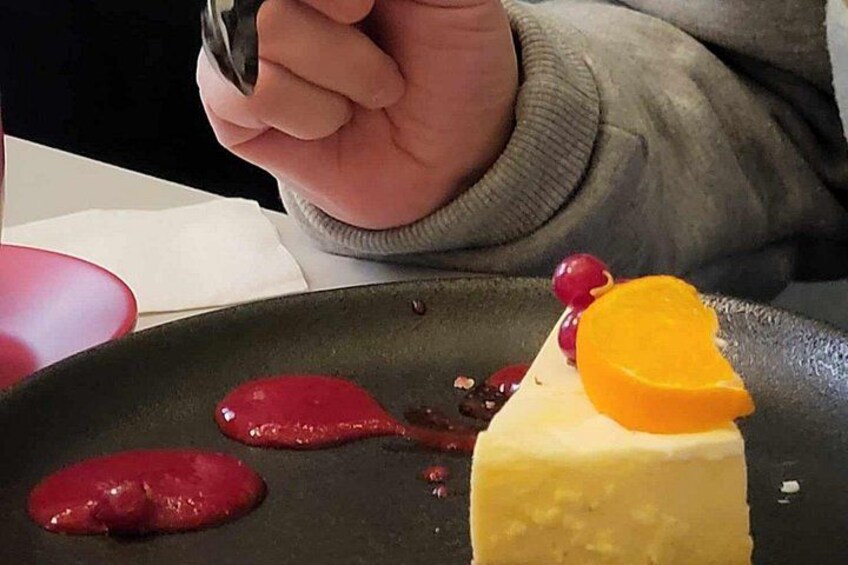 A dessert with a slice of orange and red sauce on a plate. 2