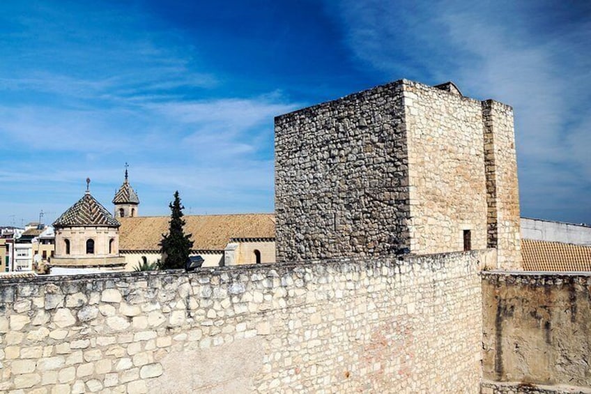 A stone wall, a church with a tiled roof, and a tower. 2