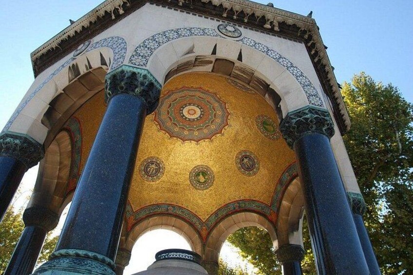 Un bâtiment historique doté de colonnes richement décorées et d’un plafond orné d’une mosaïque complexe. 3