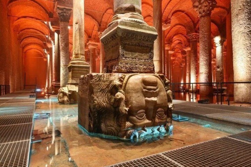 Un sito archeologico antico con colonne, una grande struttura in pietra e una piscina. 5