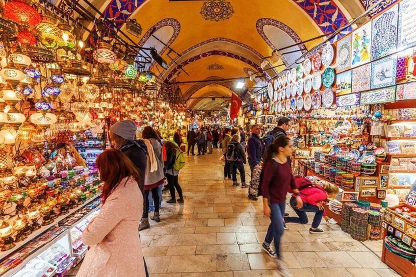 Un marché animé où les gens déambulent parmi les étals remplis de lanternes colorées et d’objets en céramique. 2