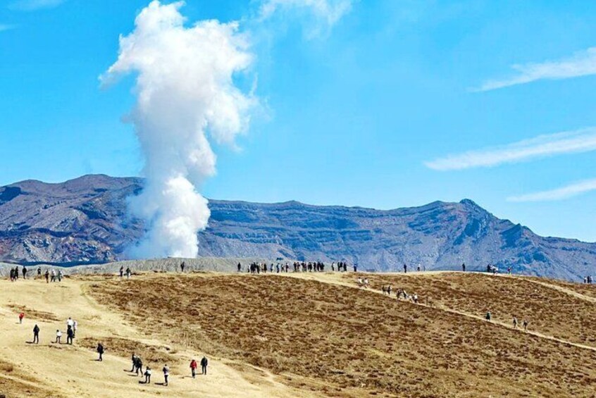 Une bouche de vapeur, un paysage aride et vallonné, et un groupe de personnes. 5
