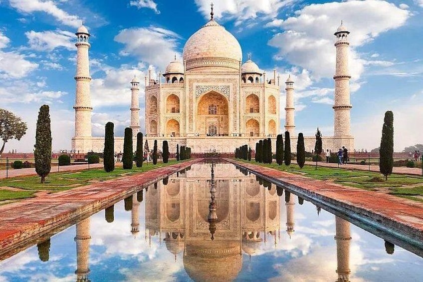 Il Taj Mahal con il suo riflesso nell'acqua, quattro minareti e un cielo sereno. 2
