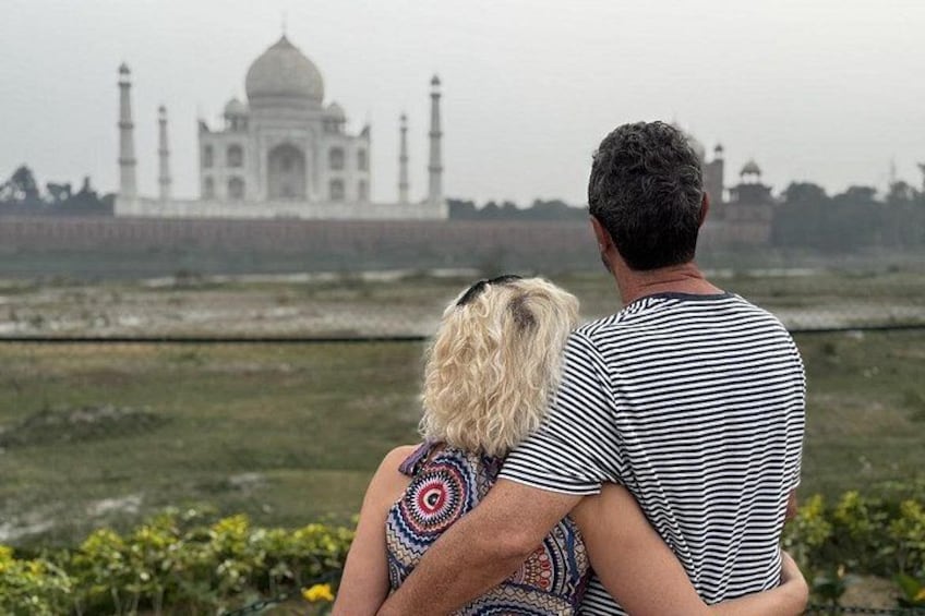 Una coppia in piedi con il Taj Mahal sullo sfondo. 3