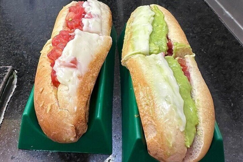 Two baguettes with different toppings on a green tray. 2