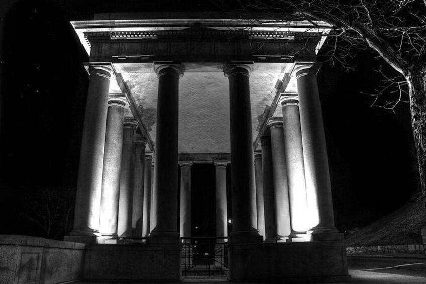A classical building with illuminated columns at night. 4