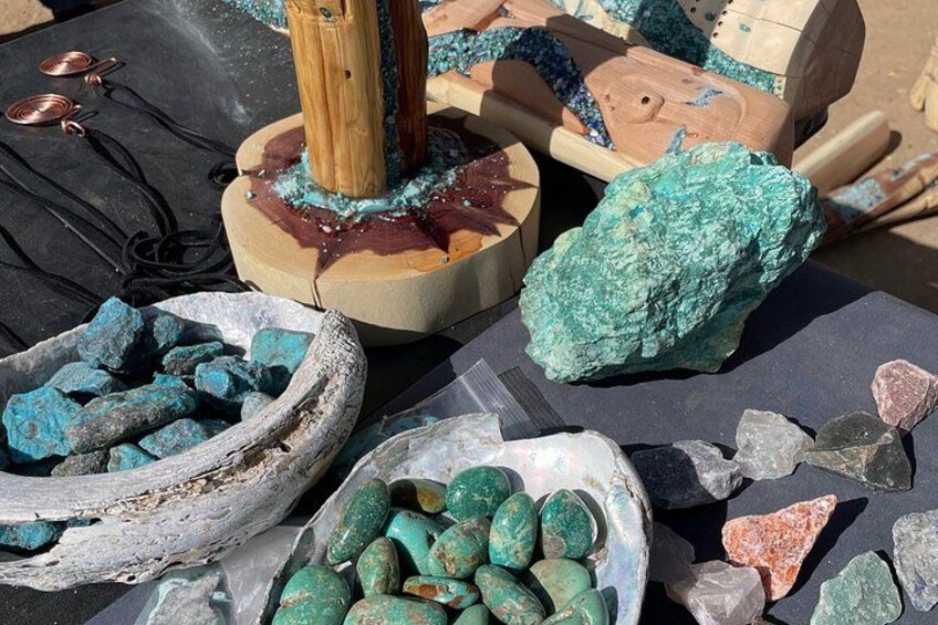 Various minerals and rocks, including turquoise and other colorful stones, displayed on a table. 2