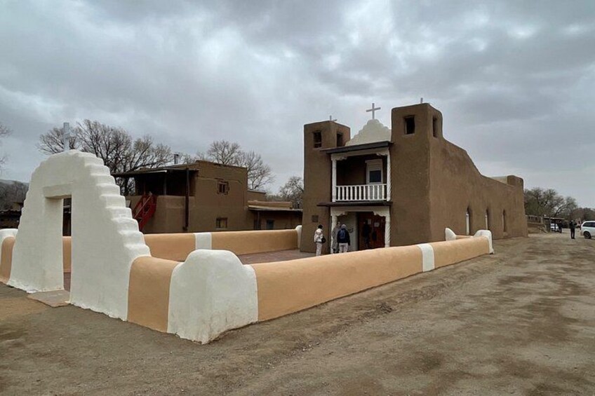 A church with a balcony and a white wall structure. 4