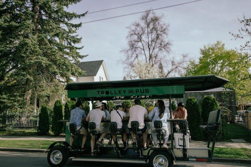 A trolley with people seated, labeled 'TROLLEY PUB,' moving along a street. 4
