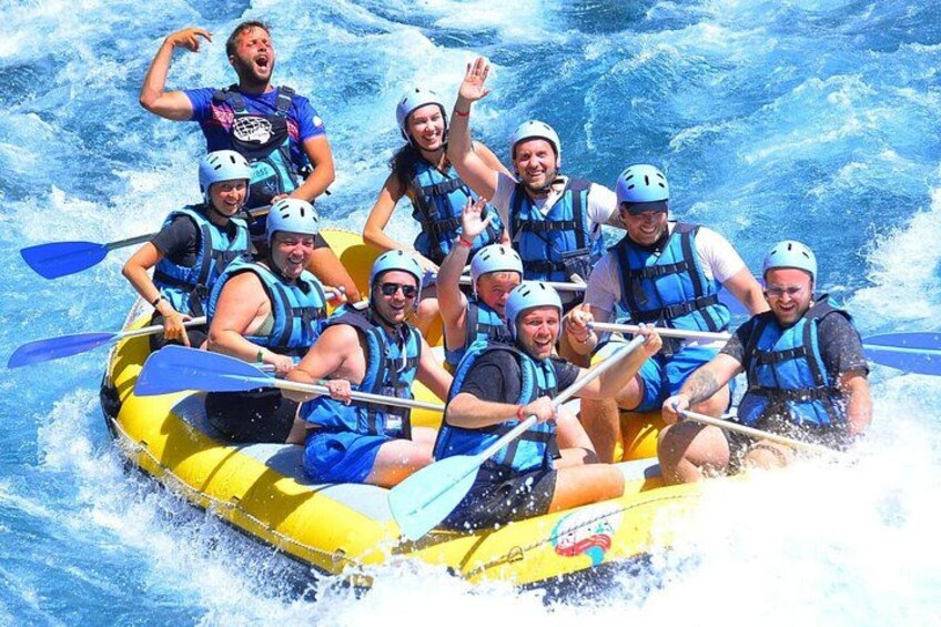 A group of people in a yellow raft navigating through white water rapids. 5