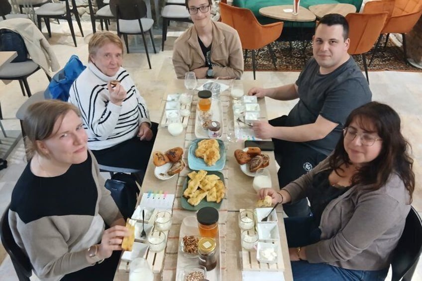 A group of people sitting around a table with food and drinks. 3