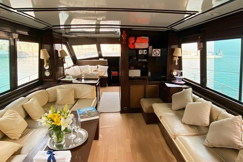 A luxurious cabin with leather sofas, a coffee table, and a view of the sea. 2