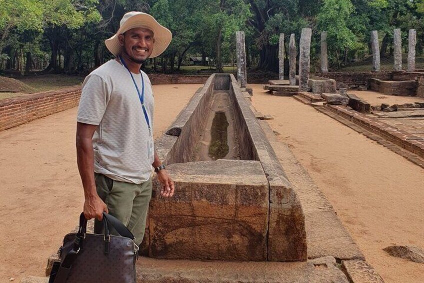 A person standing next to ancient stone structures in a historical site. 1