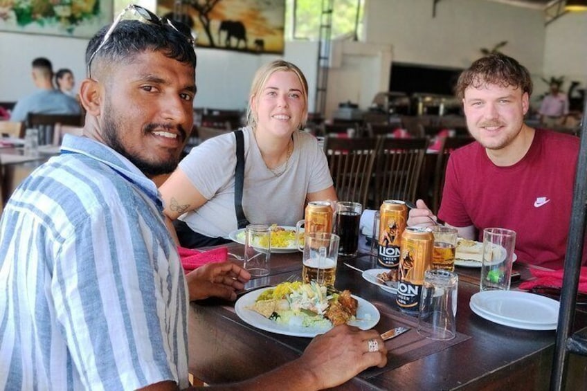 A group of people dining at an outdoor restaurant with beer glasses and plates of food. 2