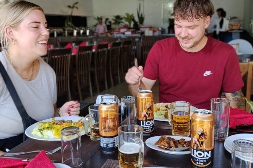 A dining table with food, drinks, and a can of beer. 3