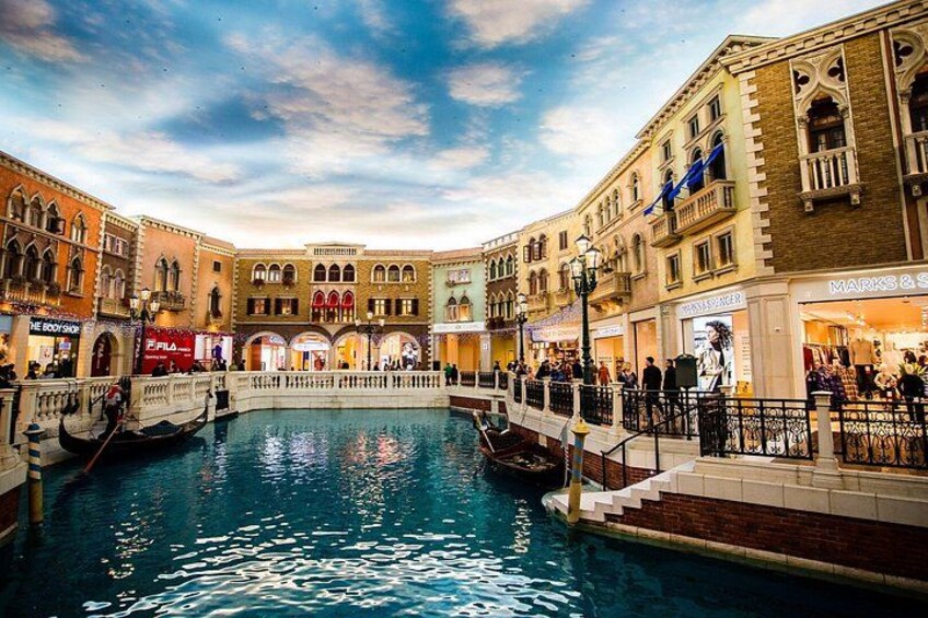 Un canal où l’on peut faire des promenades en gondole, un pont et des bâtiments abritant des boutiques. 2